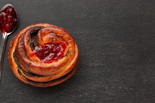 pastry with frosting and jelly filling in ring shape